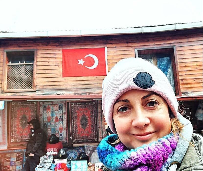 Dilek Orubegarcia in a market beneath a Turkish flag in Istanbul