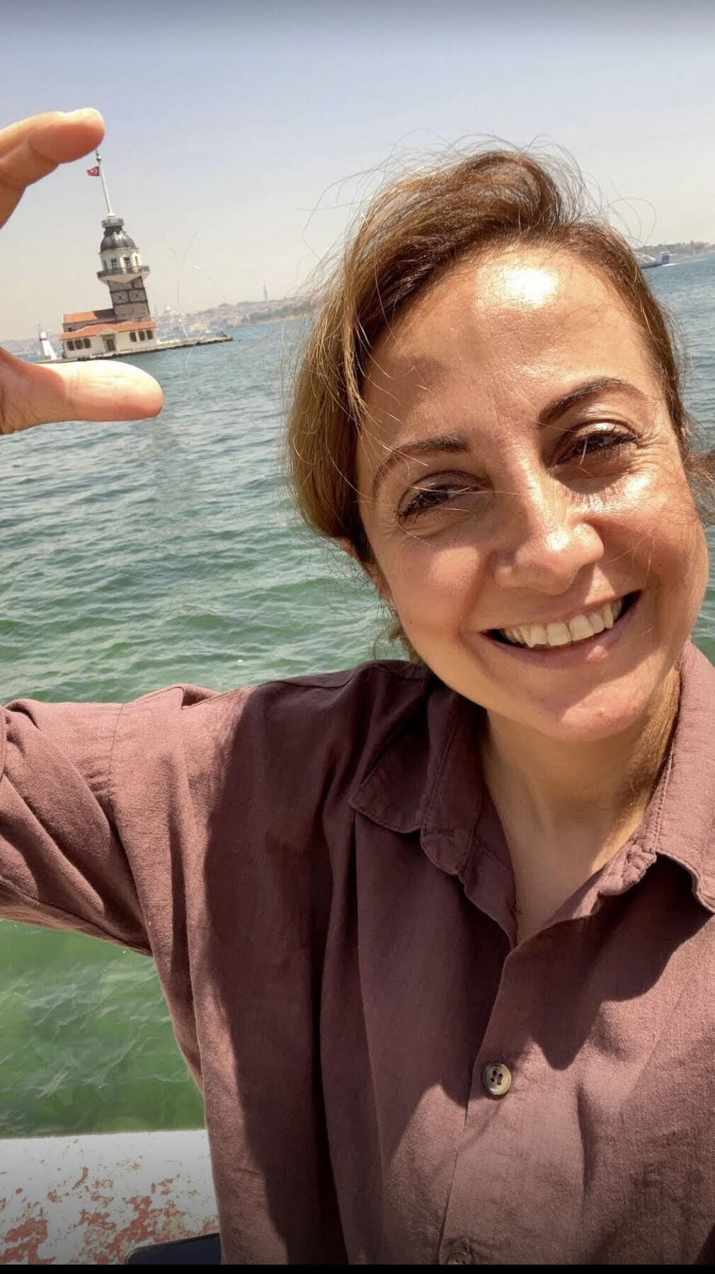 Dilek Orubegarcia with Maiden's Tower across the Bosphorus in Istanbul