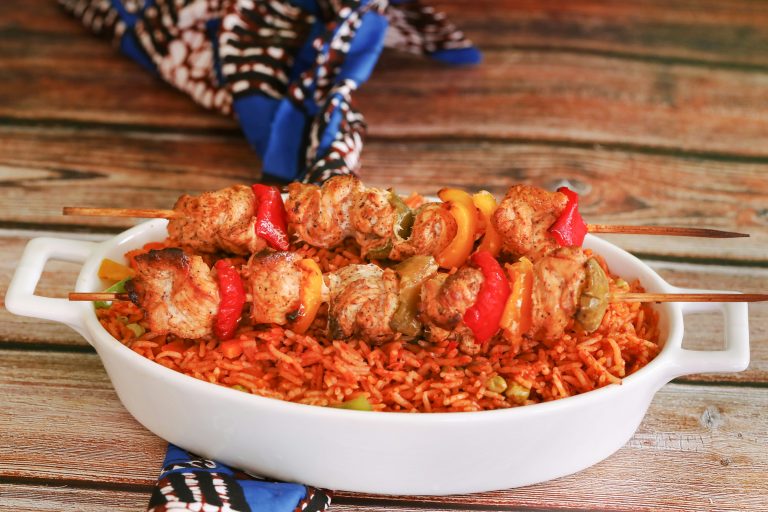 Nigerian jollof rice served with chicken skewers