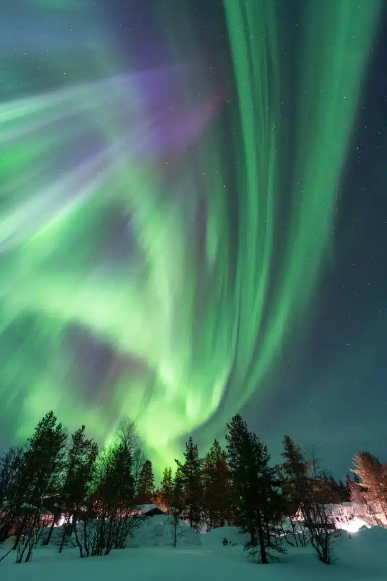 Green and purple Northern Lights across a dark sky