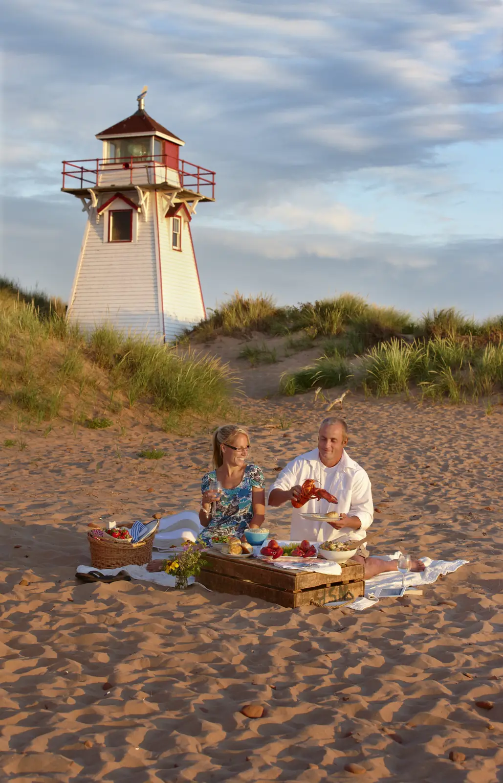 A couple beside Covehead lighthouse on Prince Edward Island