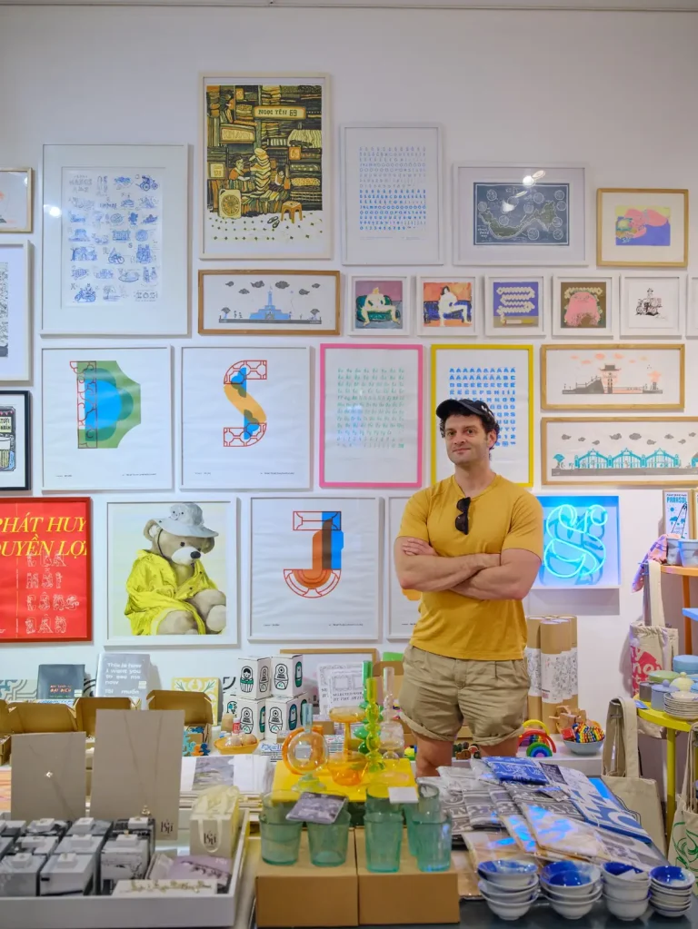 Joshua Zukas in a shop displaying Vietnamese prints and design